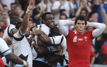 Wales' centre James Hook (R) reacts as Fiji players celebrate - Political arrest of Fiji player’s dad sparked shock 2007 World Cup win over Wales