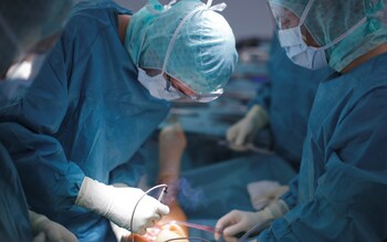 Doctors and medical staff work during a knee prosthesis surgery in an operation room at a hospital