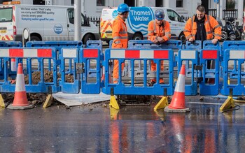 Thames Water workers in a flooded street burst water main