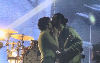 The 1975's singer Matt Healy kisses bassist Ross MacDonald after giving a speech at a music festival in Kuala Lumpur, Malaysia