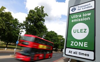 a London bus drives past a Ulez sign