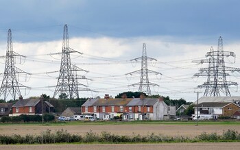 Electricity pylons behind houses in Lydd, Kent