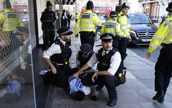 Police officers detain a man near Oxford Street in central London