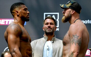 Matchroom Sport chairman and boxing promoter Eddie Hearn (centre) stands between Anthony Joshua (left) and Robert Helenius as they face off during the public weigh-in at Westfield London