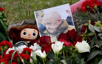 A portrait of Yevgeny Prigozhin is seen amid flowers at a makeshift memorial
