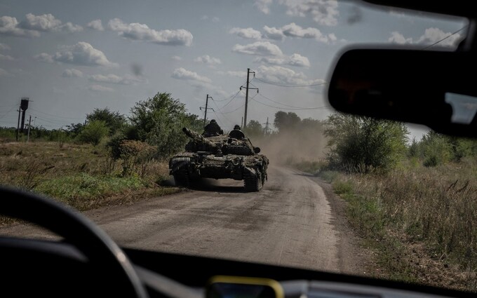 Ukrainian servicemen ride a tank