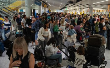 People wait near check-in desks during the chaos at Gatwick Airport last week