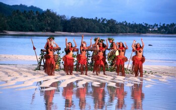 A group of Polynesian dancers on a sandbank in the Cook Islands